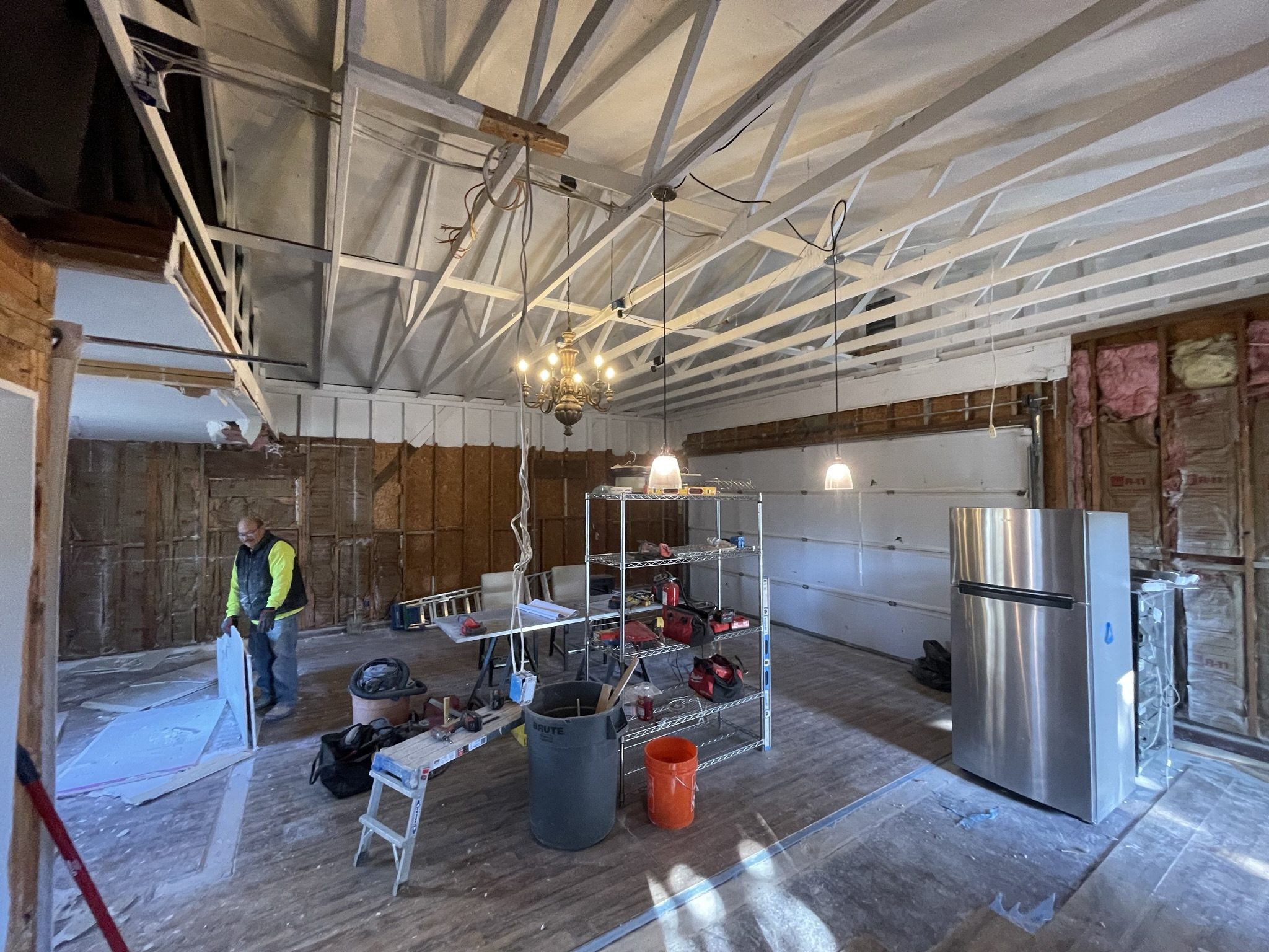 Construction process showing ceiling framing and rough-in work inside garage ADU conversion