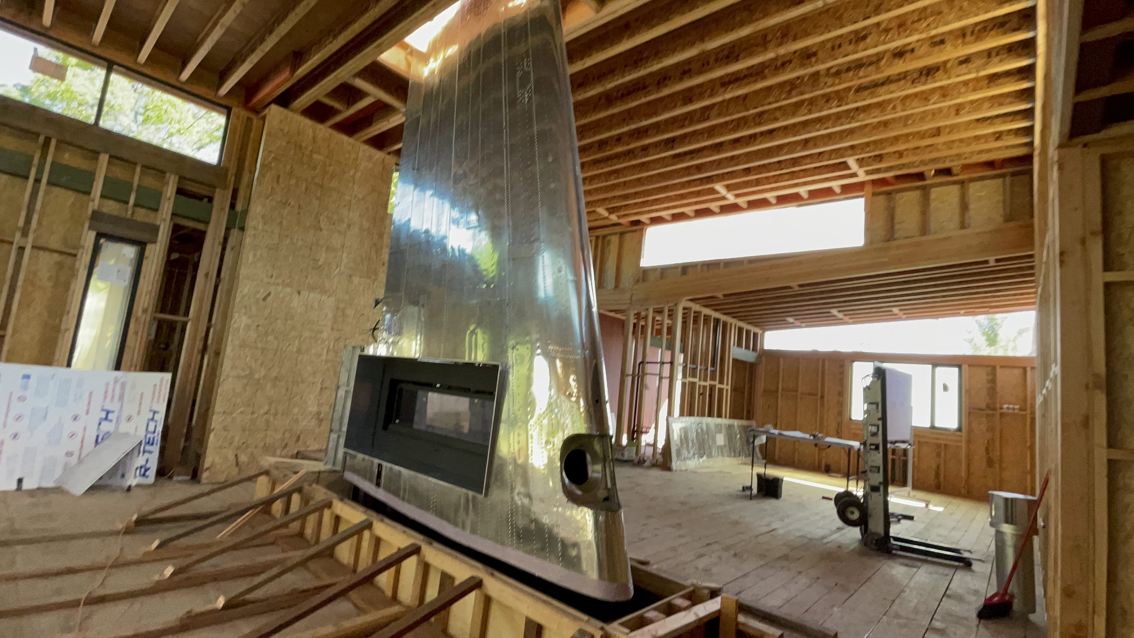 Grandview process photo showing custom metal feature, fireplace opening, and wood ceiling coordination