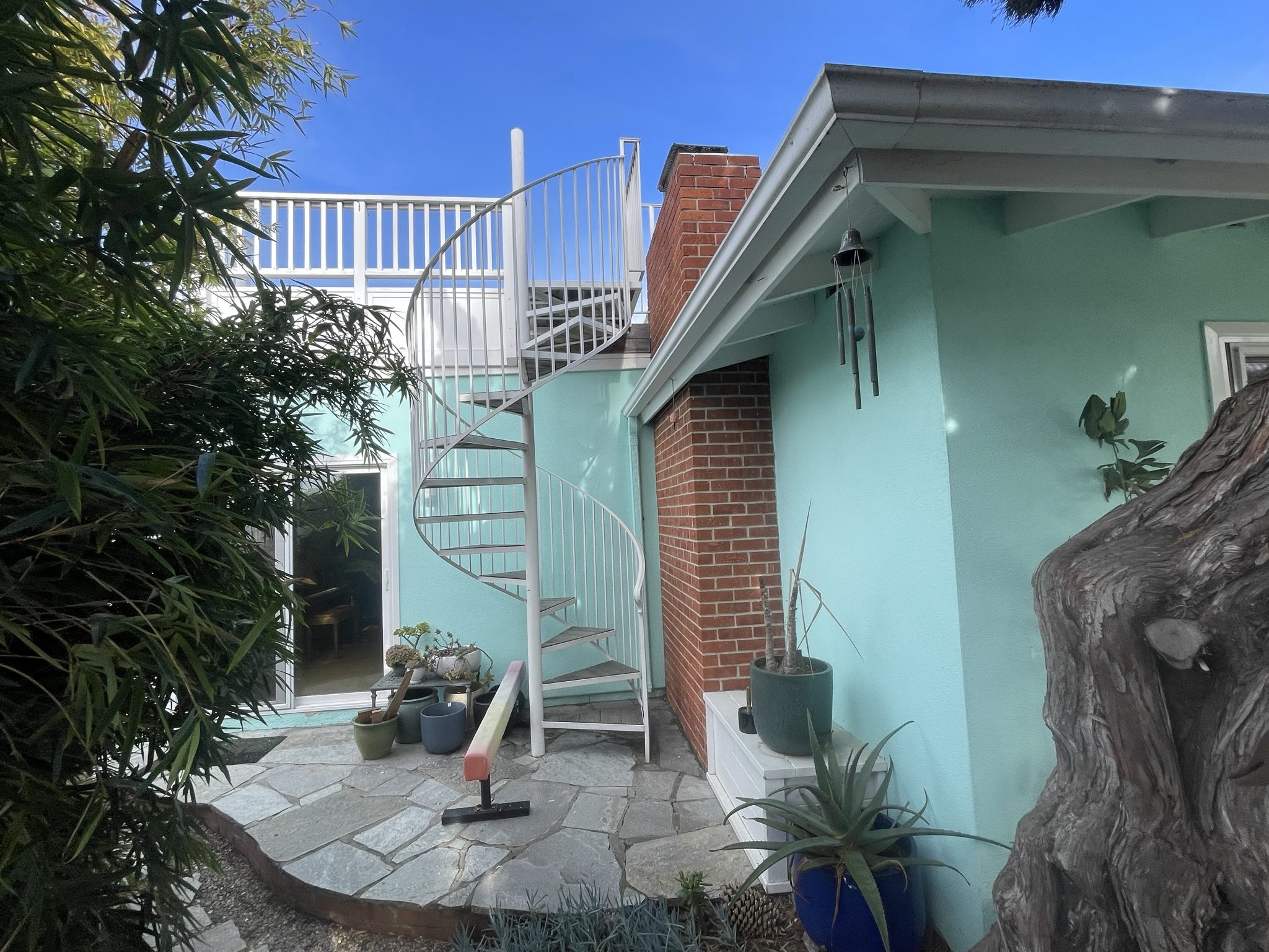 Completed exterior patio and spiral stair for a coastal second-story addition
