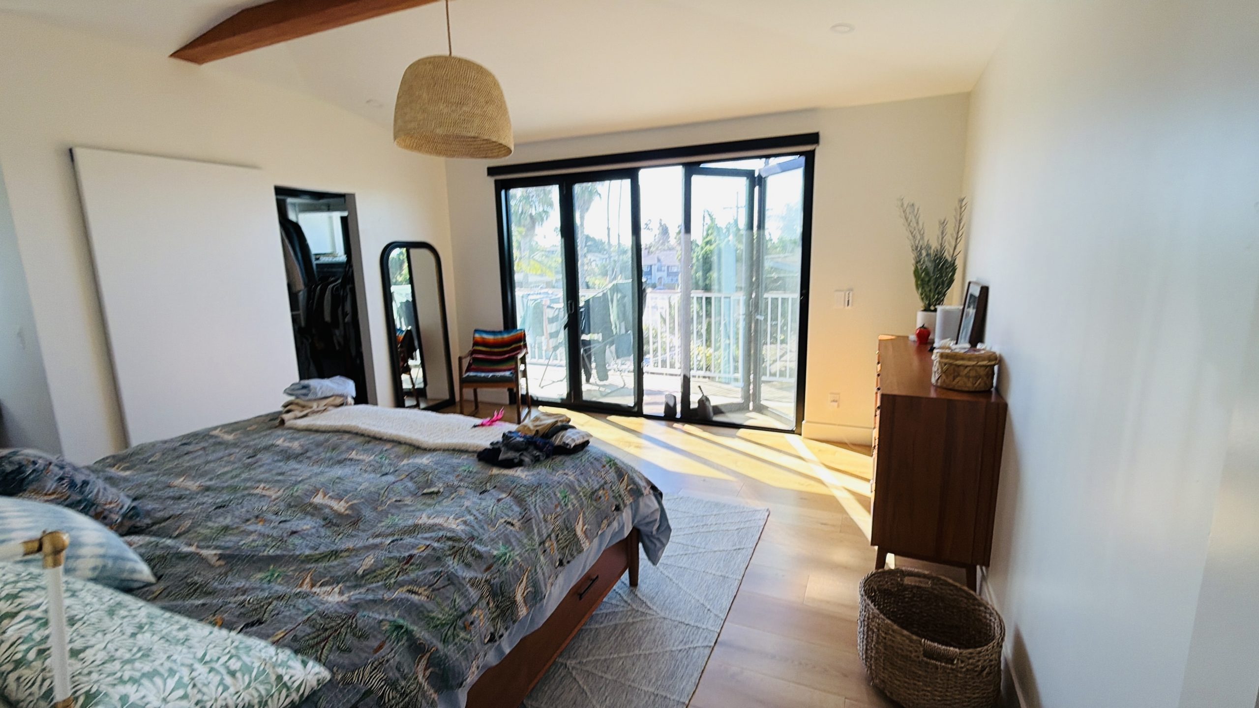 Finished primary bedroom with multi-panel doors opening to the upper deck