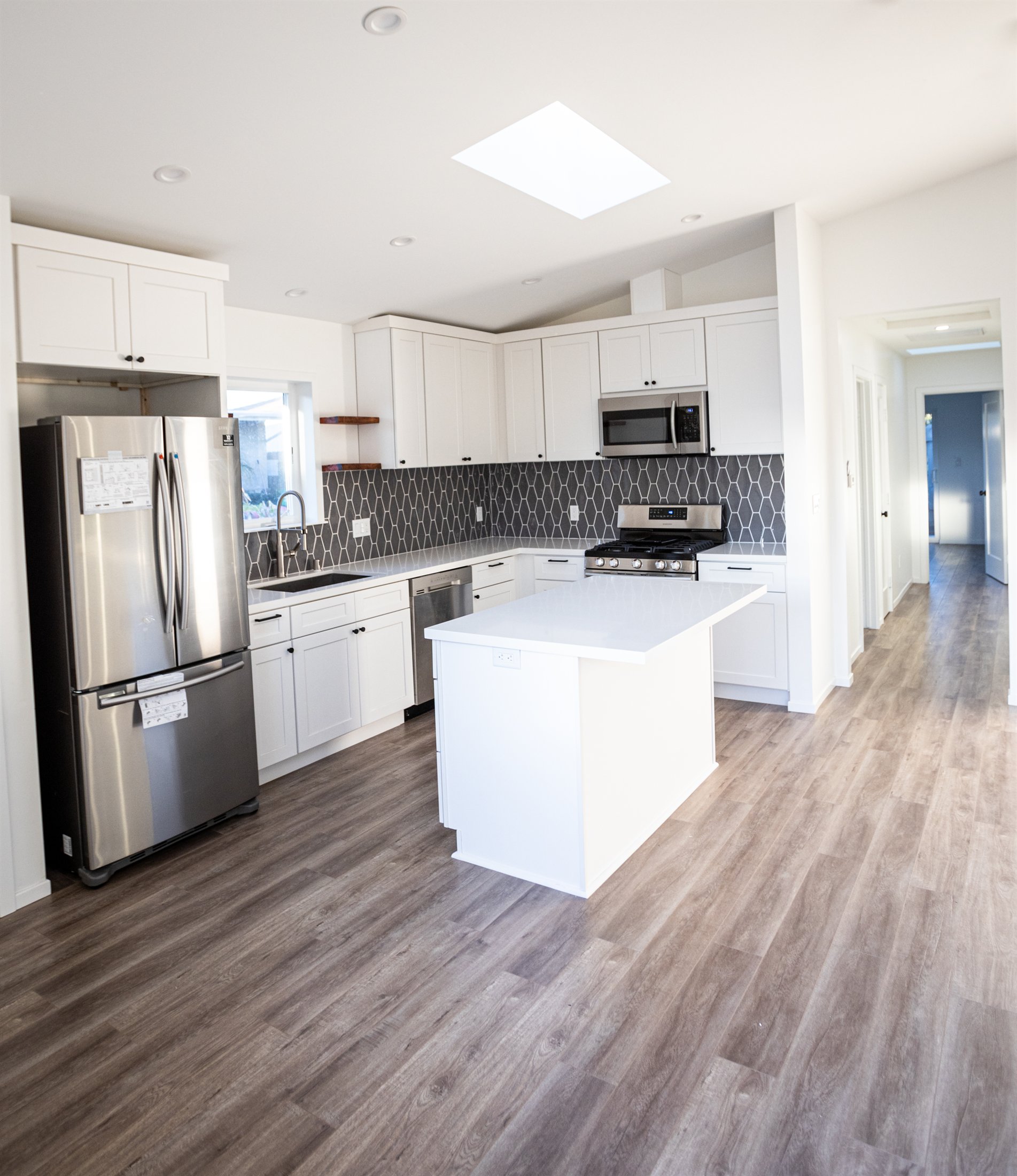 Finished compact ADU living area with durable flooring and abundant natural light