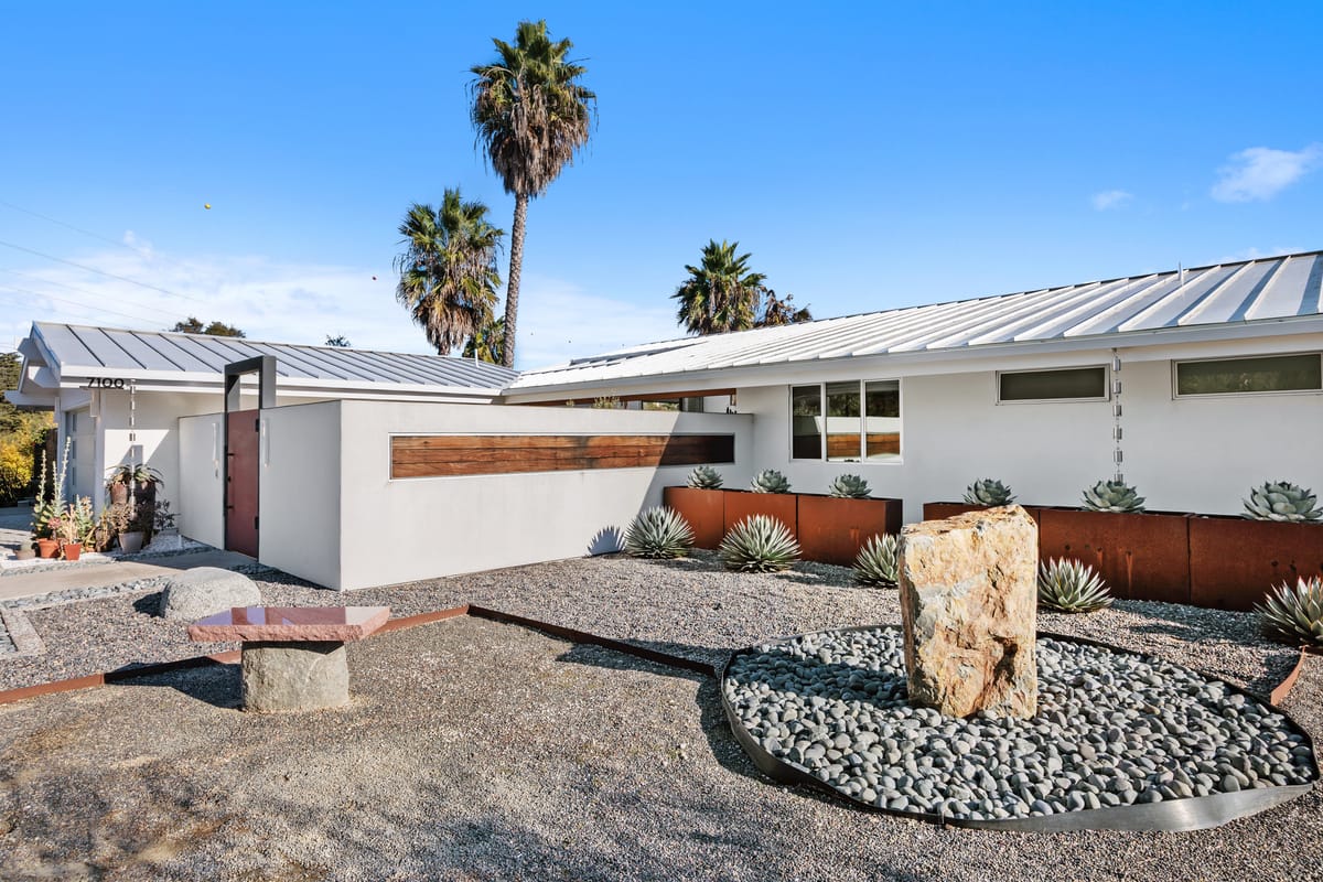 Finished Estrella exterior remodel with modern metal roof, landscape walls and drought-tolerant planting
