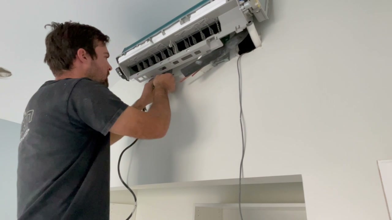 Technician installing a mini-split HVAC system in the Encinitas ADU