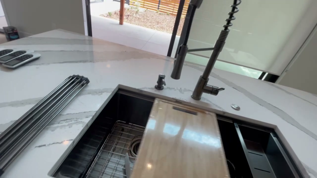Workstation sink and quartz island in the completed Encinitas ADU kitchen
