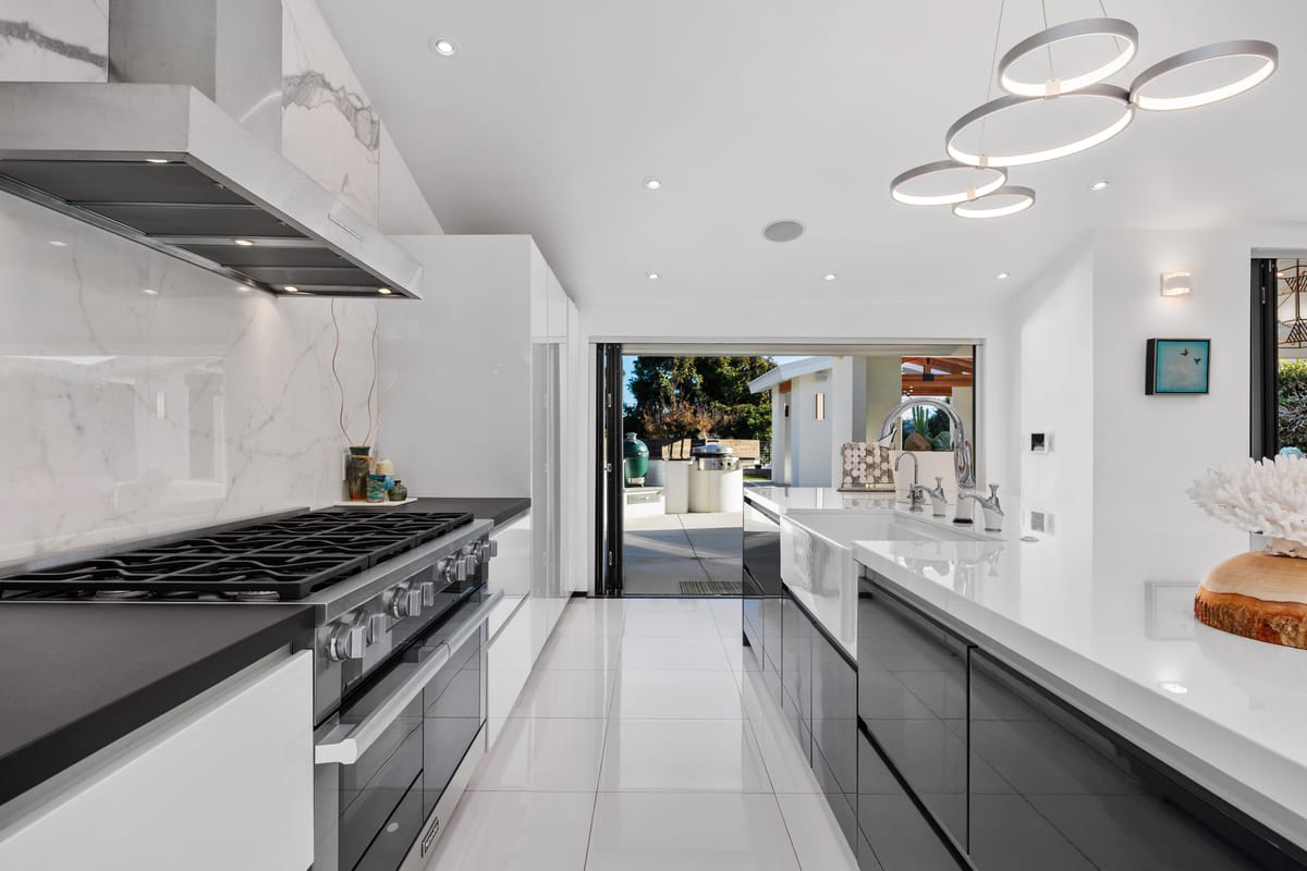 Estrella del Mar remodel: Kitchen range framed by a full-height stone backsplash.